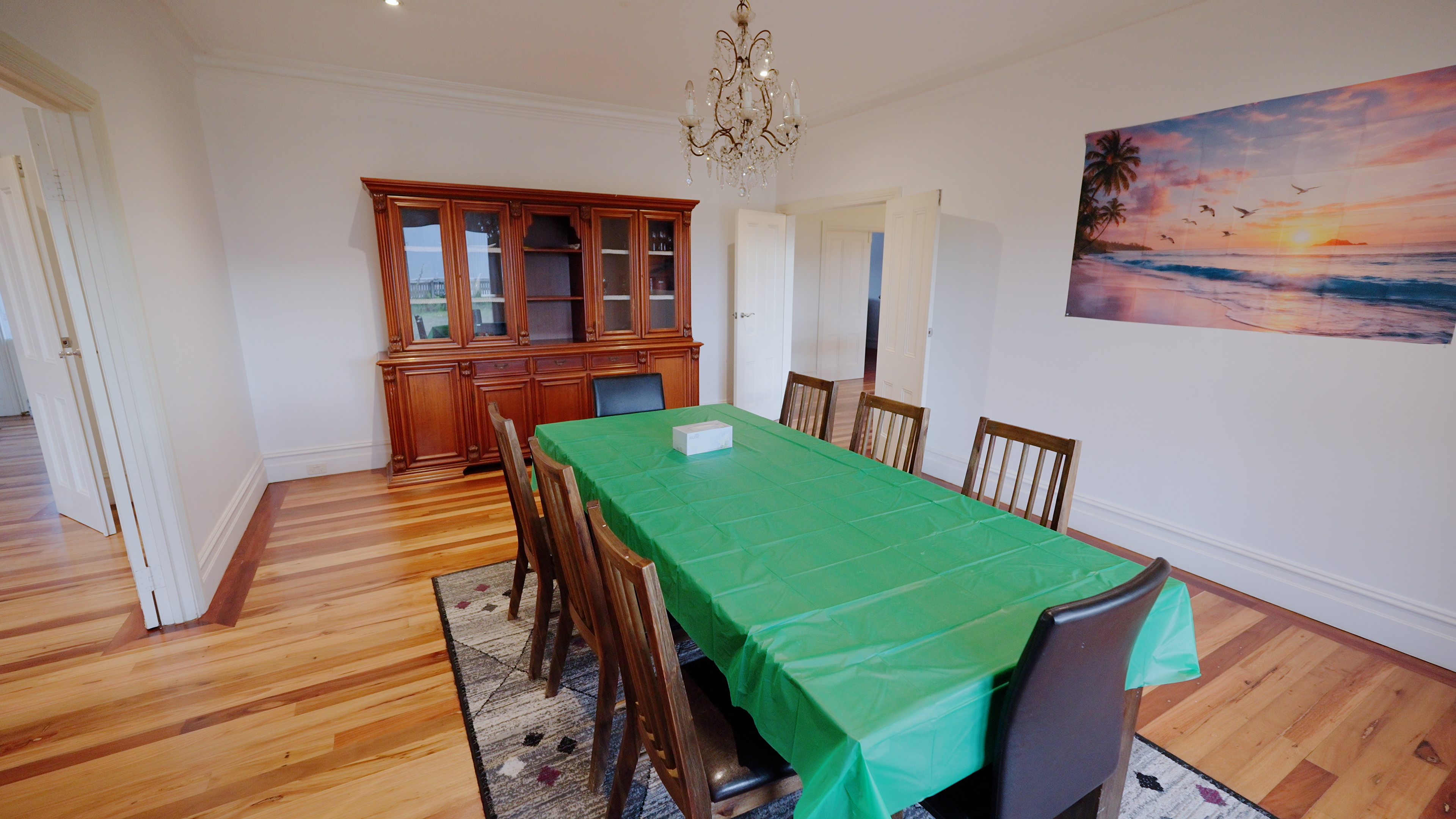 Formal dining room with timber furniture and ocean artwork