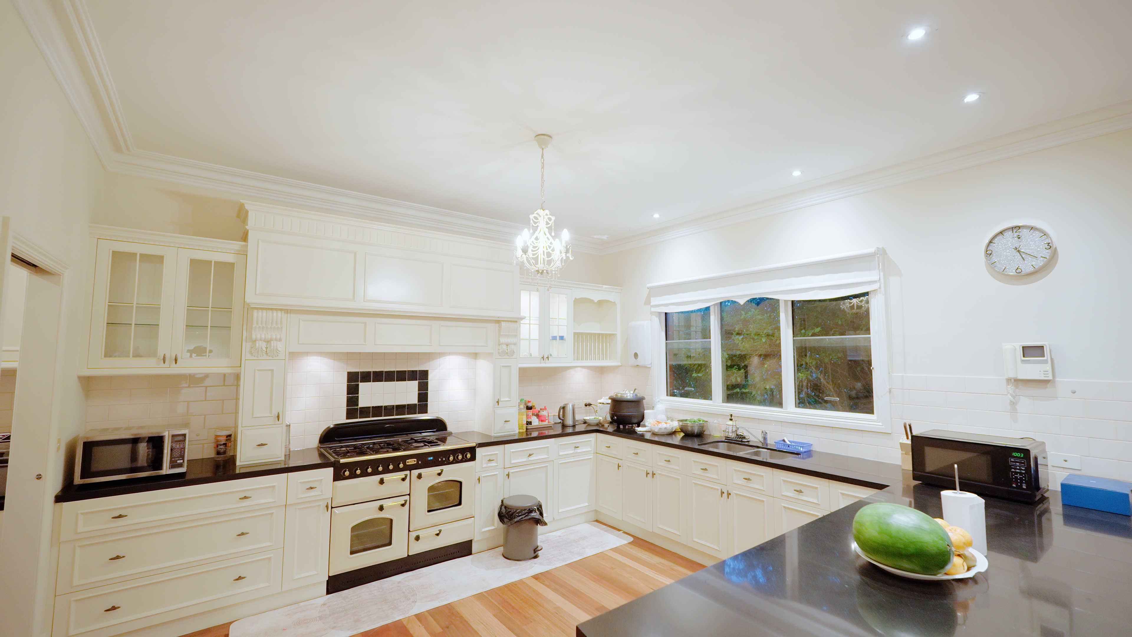 Fully equipped country kitchen with chandelier and stone benchtops